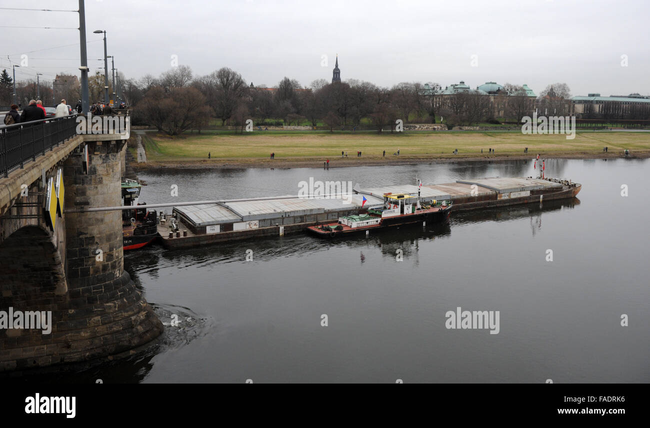 Drazdany, Germania. 28 dicembre, 2015. Rimorchiatore ceca è bloccato sotto il Marienbruecke ponte sul fiume Elba a Dresda, Germania, 28 dicembre 2015. Il Labe (Elba) Autorità di Bacino del fiume ha inviato un'onda lungo il fiume per aiutarci a salvare un ceco nave da carico. Il 90 metri di nave con un carico di peso 1100 tonnellate è rimasto bloccato in Germania durante il suo viaggio a Decin, Boemia settentrionale, domenica 27. © Libor Zavoral/CTK foto/Alamy Live News Foto Stock