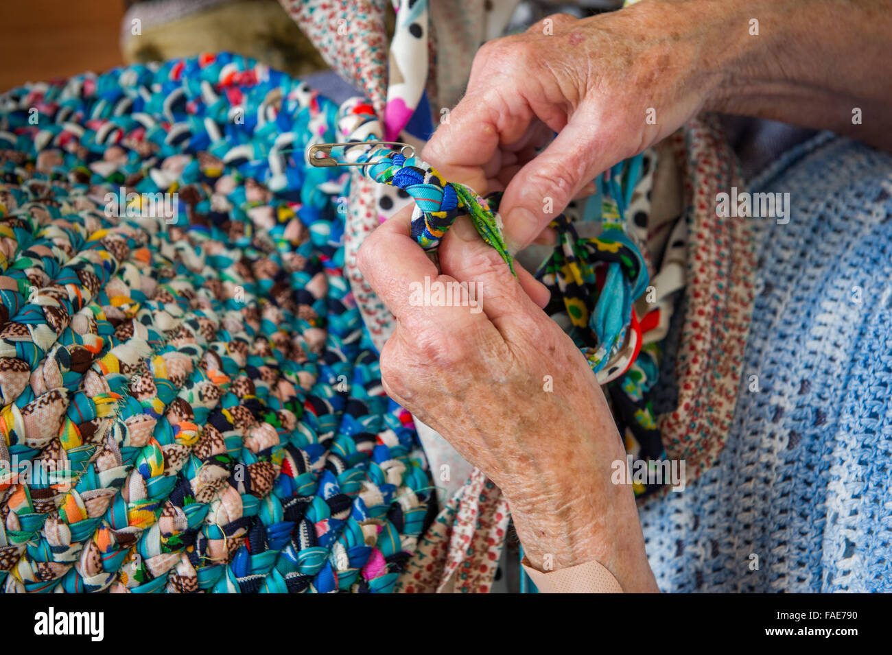 Donna anziana intreccio di un tappeto. Foto Stock
