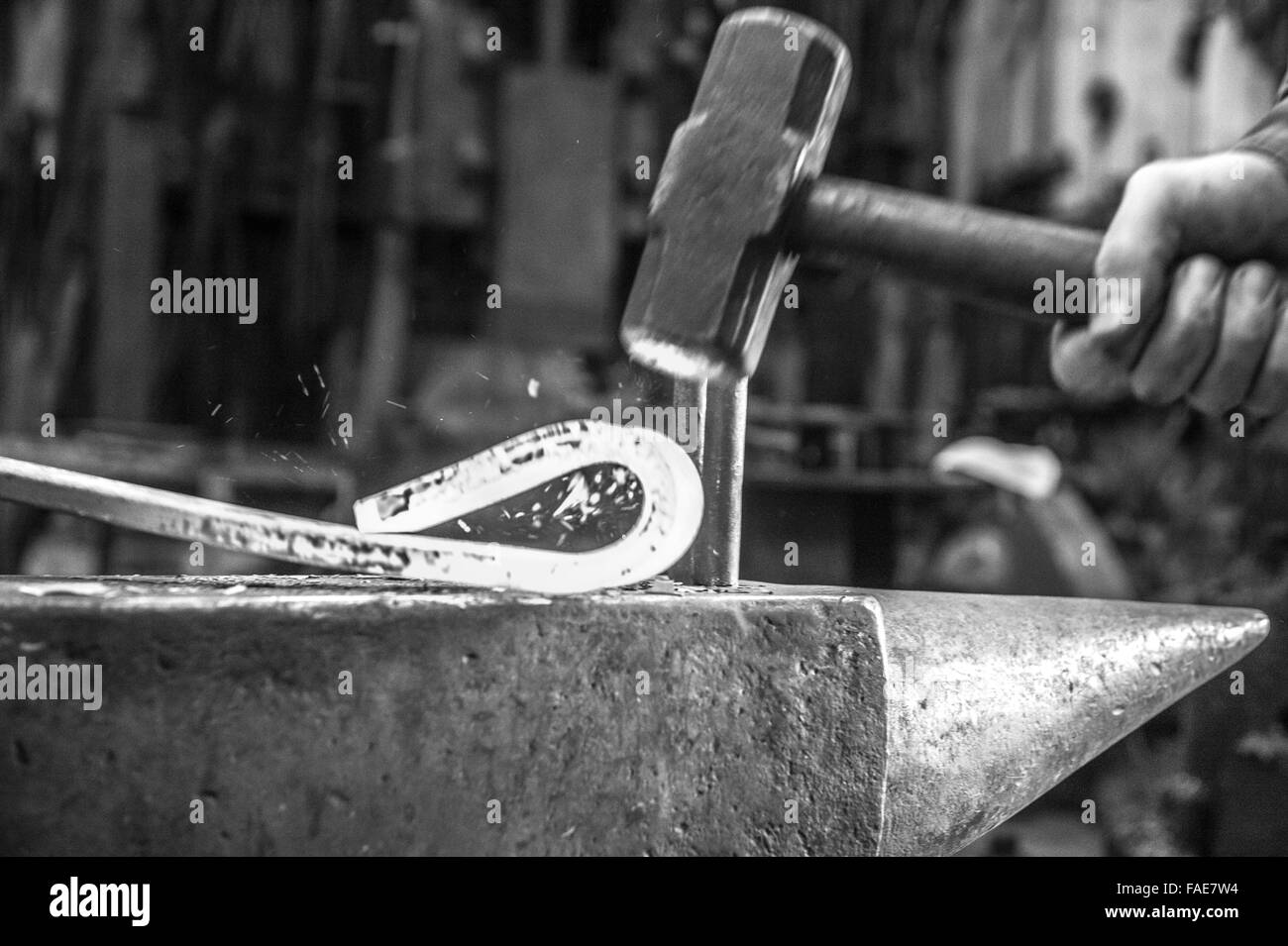 Un mazzuolo di colpire il metallo caldo in una la fucina di fabbro ferraio di Foto Stock