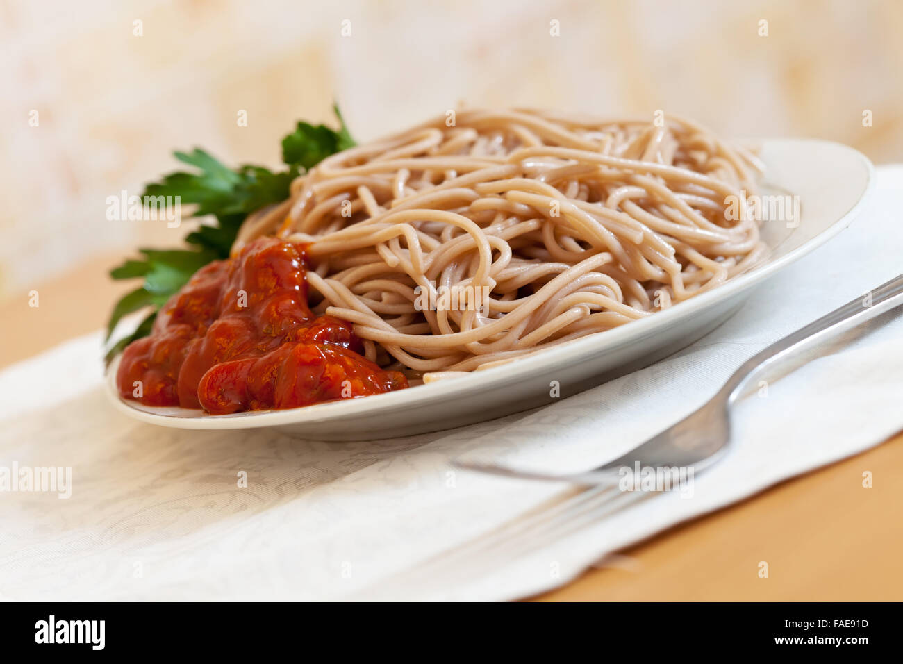 Il grano saraceno spaghetti al pomodoro catchup nella piastra sulla tavola Foto Stock