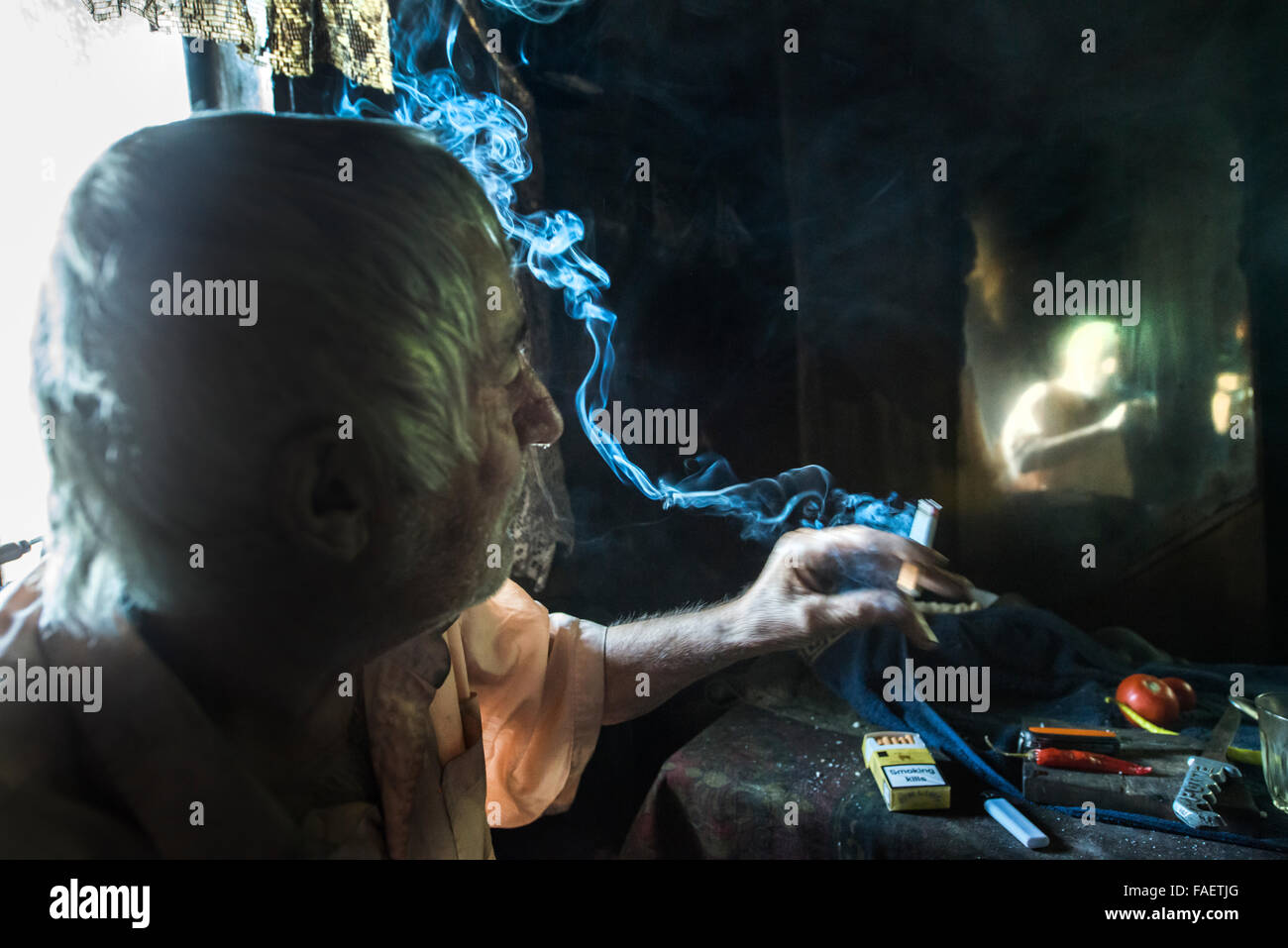 Un uomo in fumo davanti a uno specchio Foto Stock