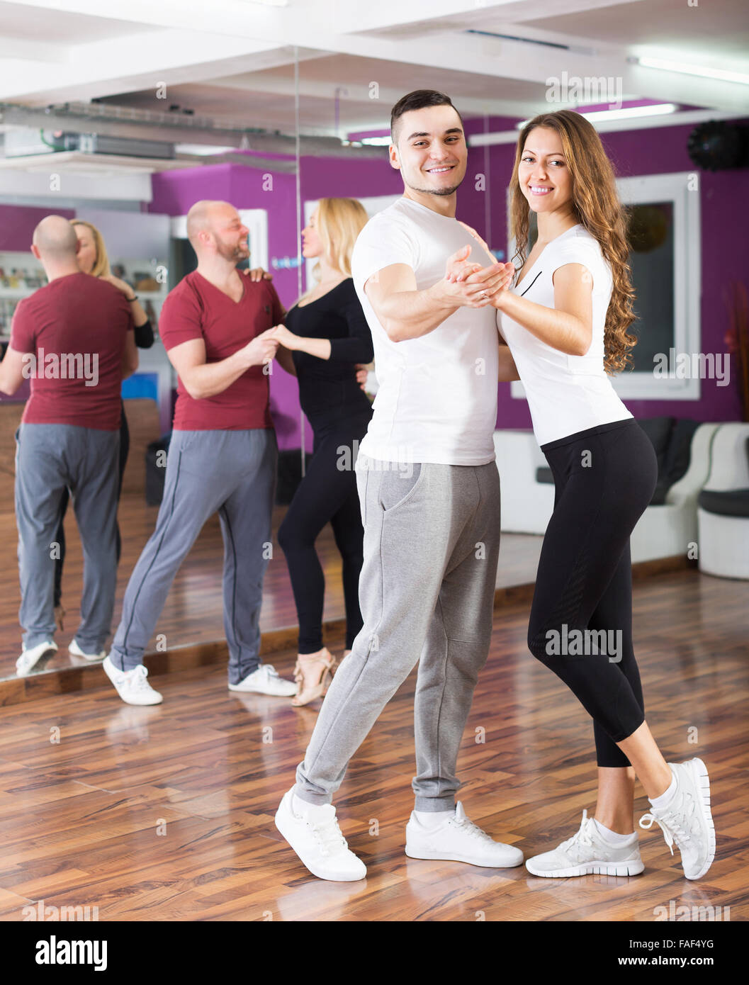 Adulto felice coppie godendo di partner dance e sorridente indoor Foto Stock