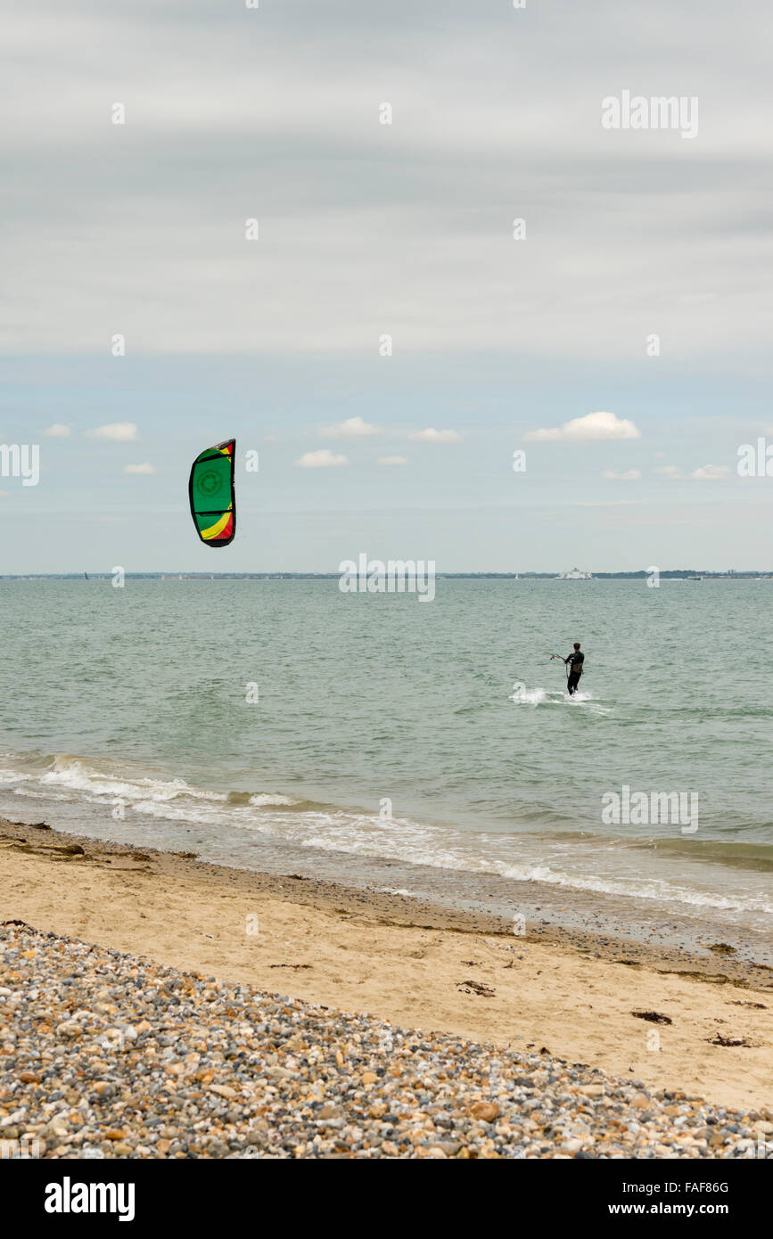 Un Kite Surf kitesurf sul mare e sull'Isola di Wight REGNO UNITO su un nuvoloso giorno Foto Stock