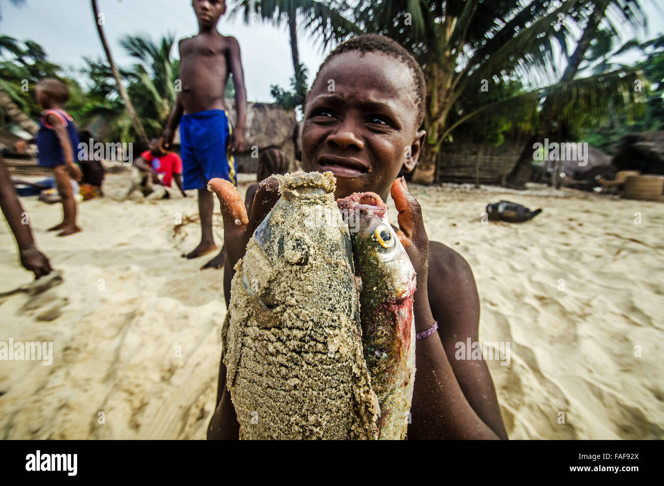 Ragazzo con pesce sulle isole di tartaruga, Sierra Leone. Foto Stock