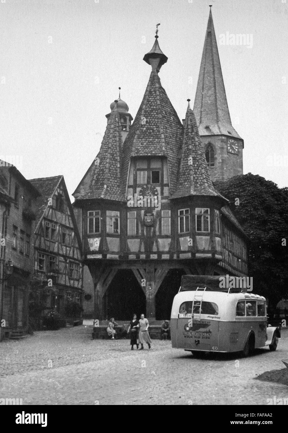 Il Rathaus und Kirche in Michelstadt im Odenwald mit Reisebus davor, Deutschland 1930er Jahre. Autobus di fronte al municipio e chiesa a Michelstadt in corrispondenza della regione di Odenwald, Germania 1930s. Foto Stock