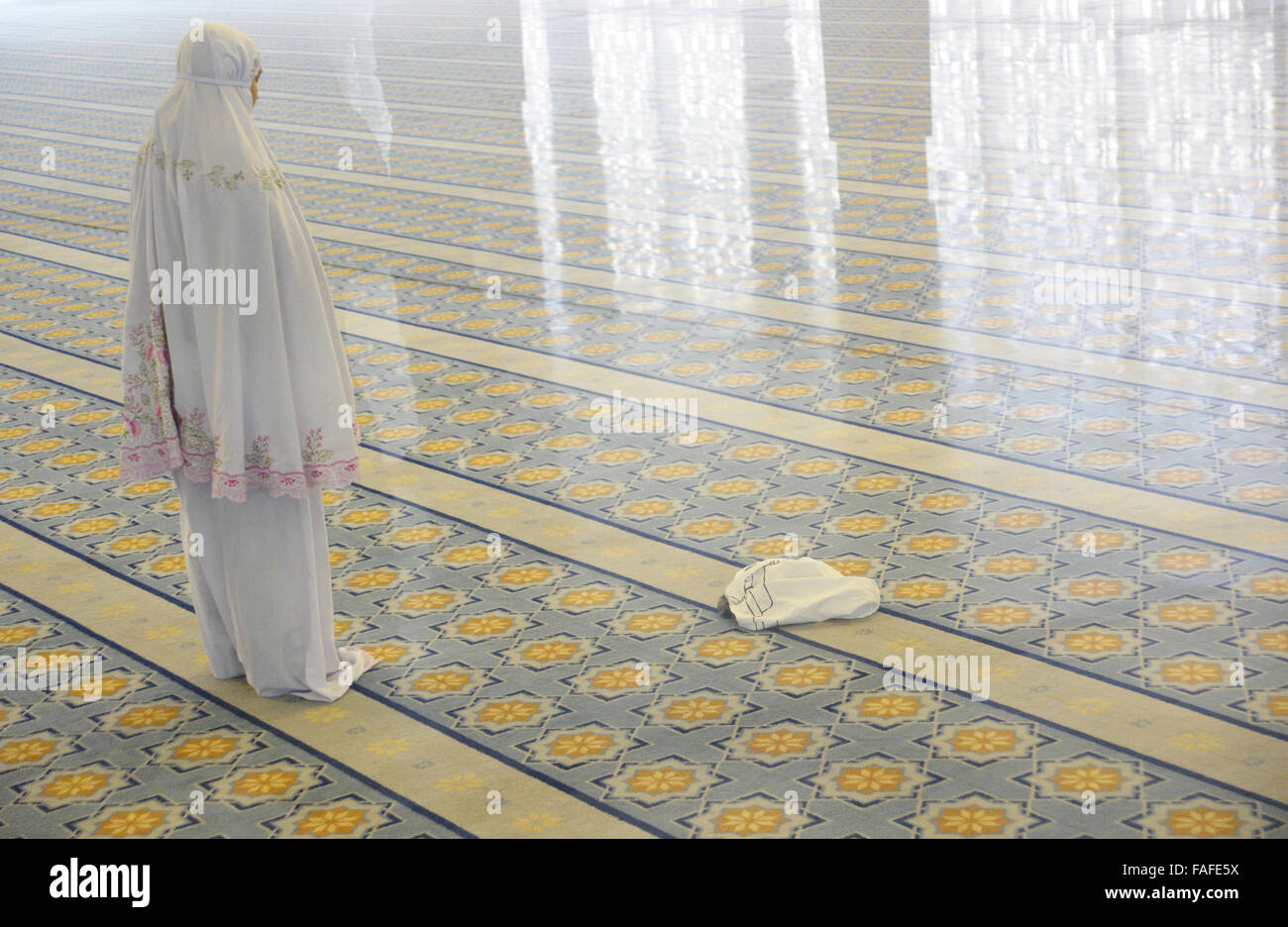 Pie donne musulmane in preghiera nella moschea da soli Foto Stock