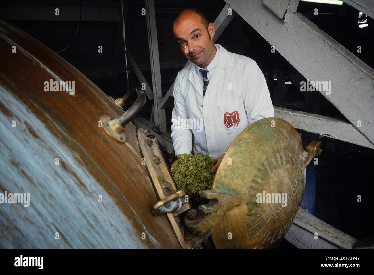 MD Stuart Bateman accanto al rame antico forno a Batemans Brewery. Tutti Wainflee Saintst. Lincolnshire. In Inghilterra. Regno Unito Foto Stock