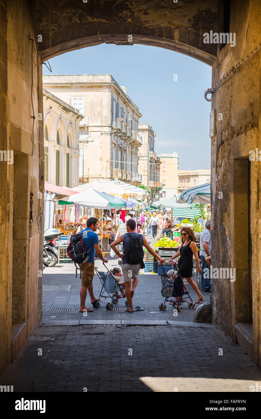 La gente della Sicilia, vista dei padri siciliani con i loro figli in poltroncine che chiacchierano durante un viaggio di shopping al mercato di Ortigia, Siracusa, Sicilia. Foto Stock