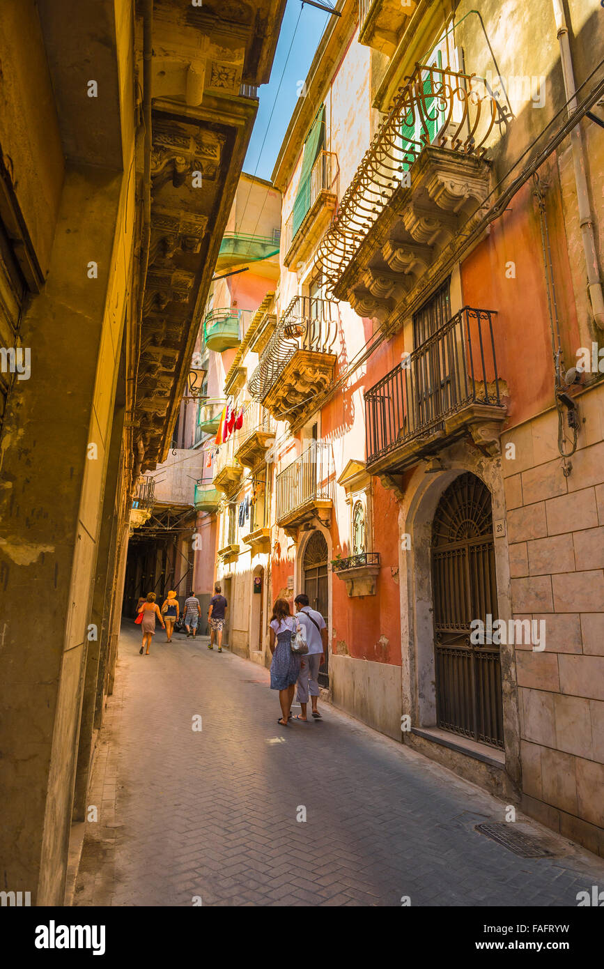 Via Sicilia, vista in estate di una giovane coppia che cammina in una stretta strada nella storica Ortigia, Siracusa (Siracusa) Sicilia, Foto Stock