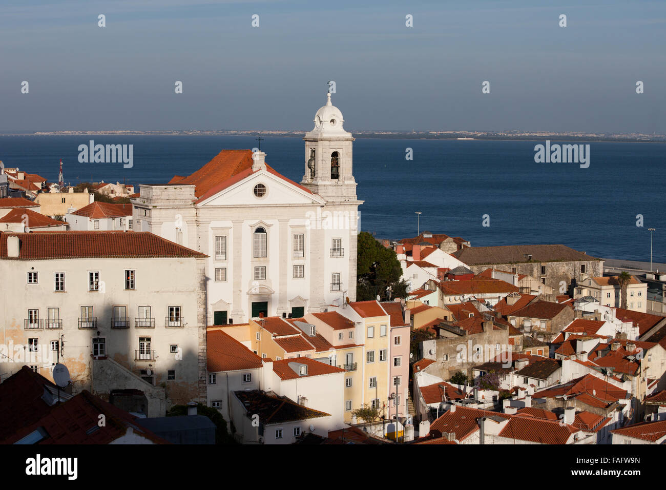 La città di Lisbona in Portogallo, quartiere di Alfama con Santo Estevao chiesa e il fiume Tago in background. Foto Stock