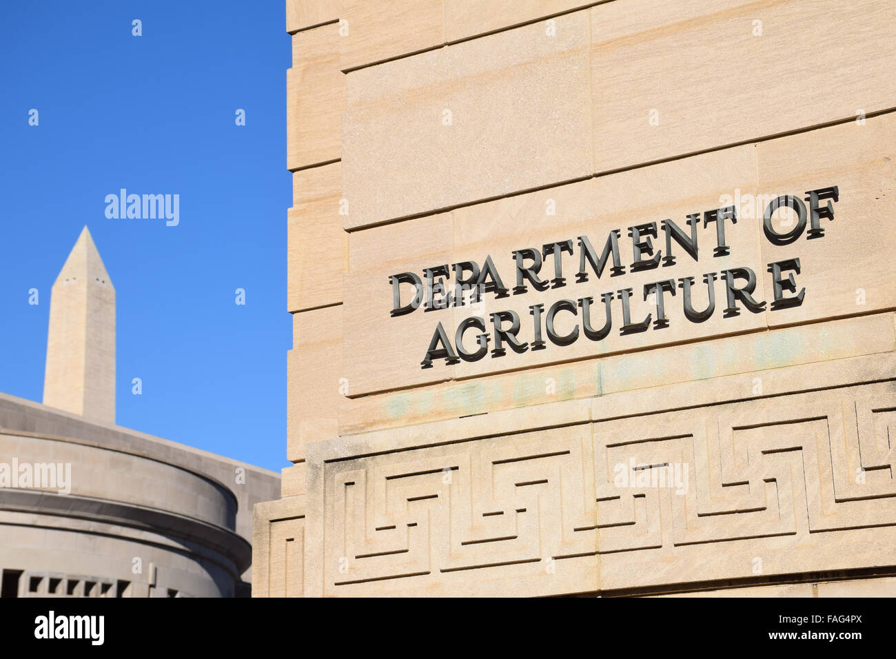 Jamie L Whitten Building Washington Monument Washington DC // WASHINGTON DC — il Jamie L. Whitten Building, sede del Dipartimento dell'Agricoltura degli Stati Uniti, si trova in primo piano con la sua facciata neoclassica. Dietro di esso, l'iconico monumento a Washington si innalza nel cielo, creando un contrasto sorprendente tra l'architettura amministrativa della città e il suo punto di riferimento più famoso. Foto Stock