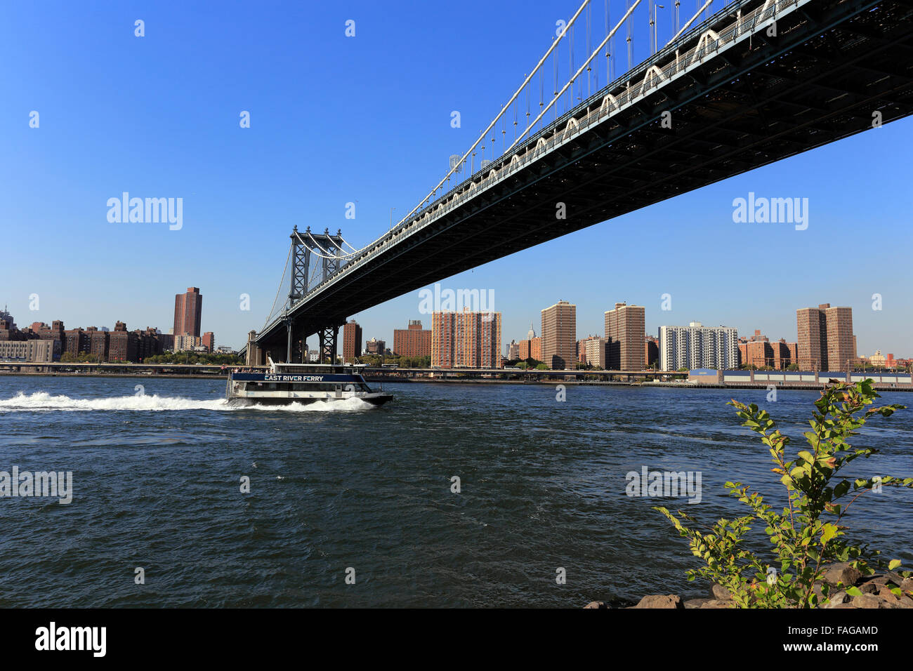 Il traghetto passa sotto il ponte di Manhattan East River New York City Foto Stock