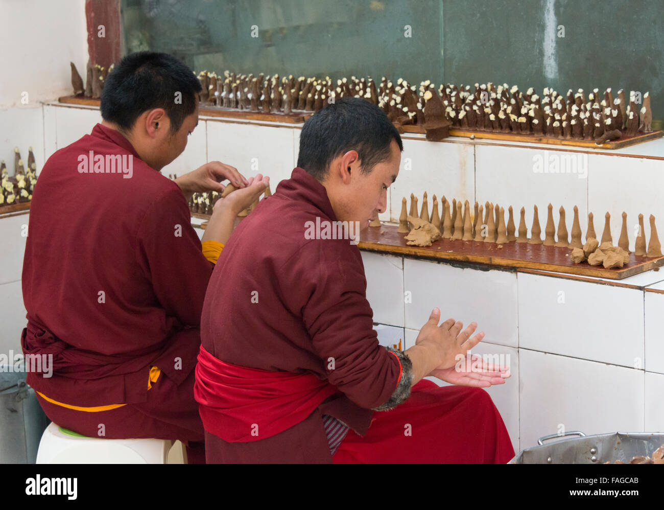 I monaci rendendo Zangba offerte sacrificali (orzo farina mescolata con burro), Seda Larong Wuming, garze, Sichuan, in Cina Foto Stock