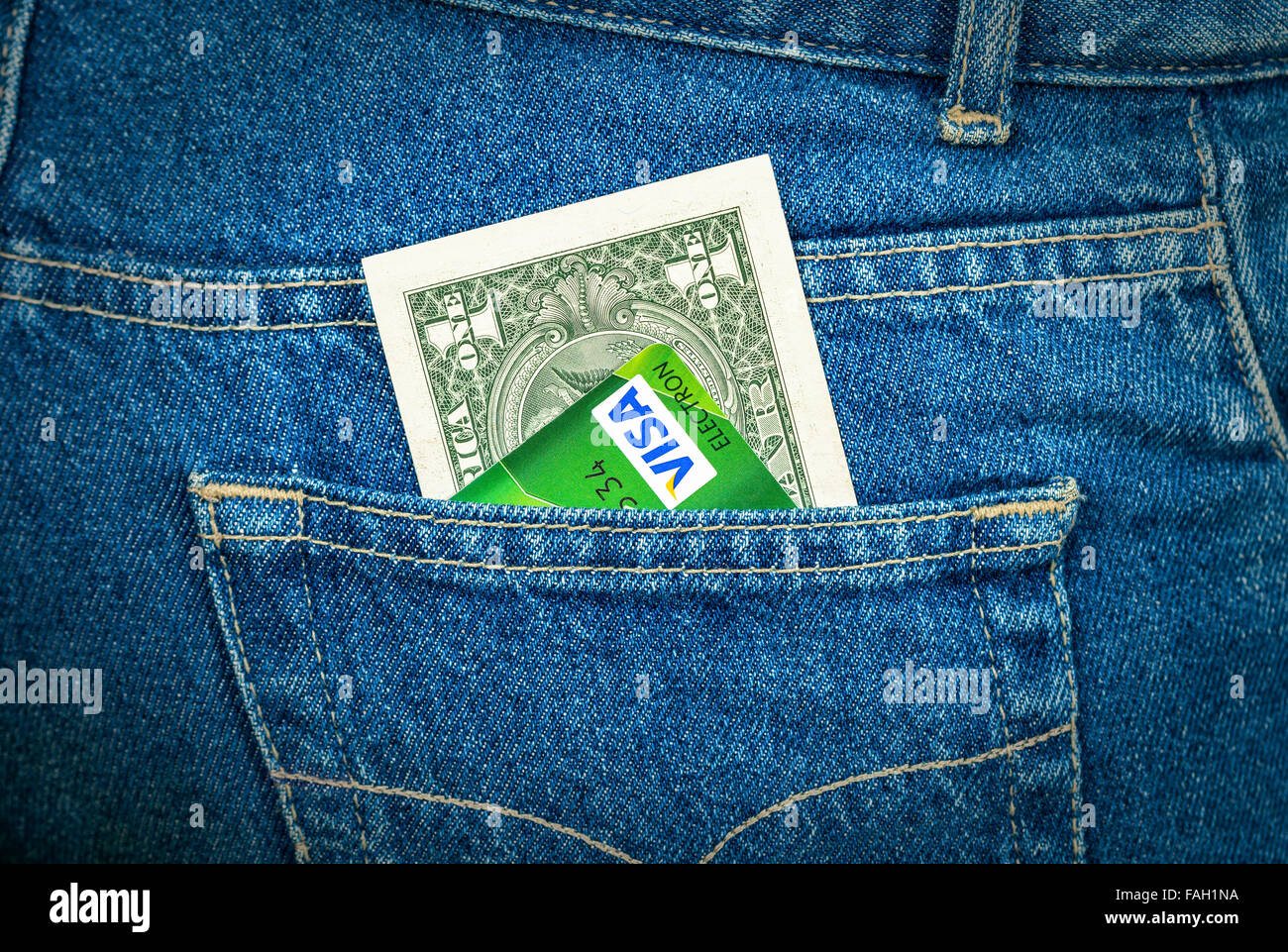 Un dollaro statunitense e la carta di credito Visa fuori della schiena tasca dei jeans Foto Stock