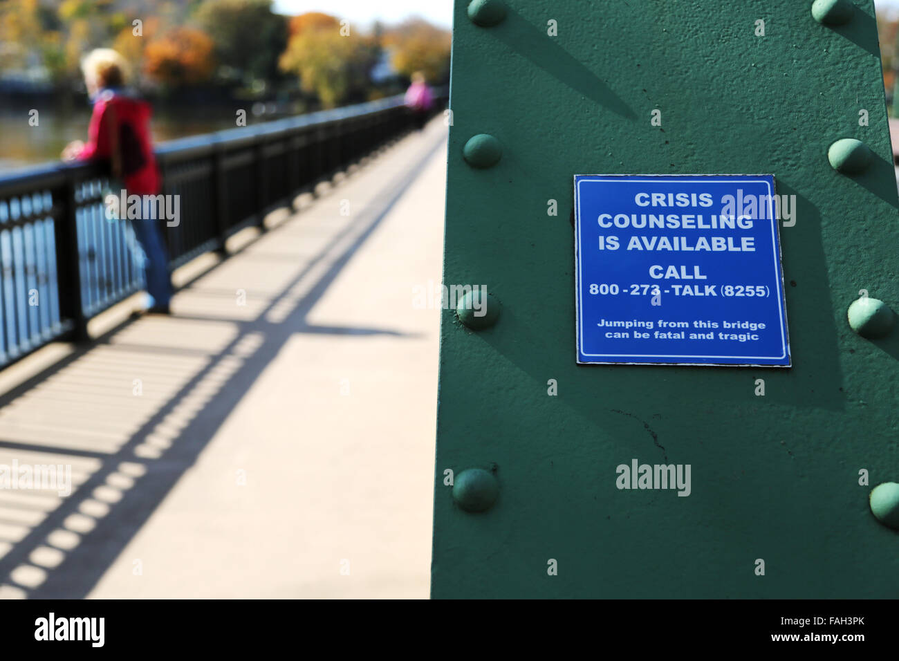 Un ponte segno di avvertimento suicida per le persone con i numeri di telefono per le crisi counseling Foto Stock