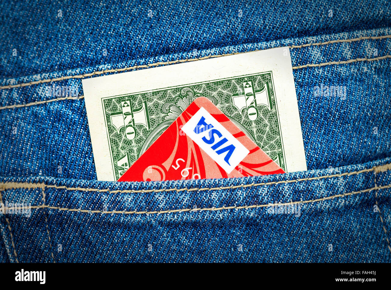 Un dollaro statunitense e la carta di credito Visa fuori della schiena tasca dei jeans Foto Stock