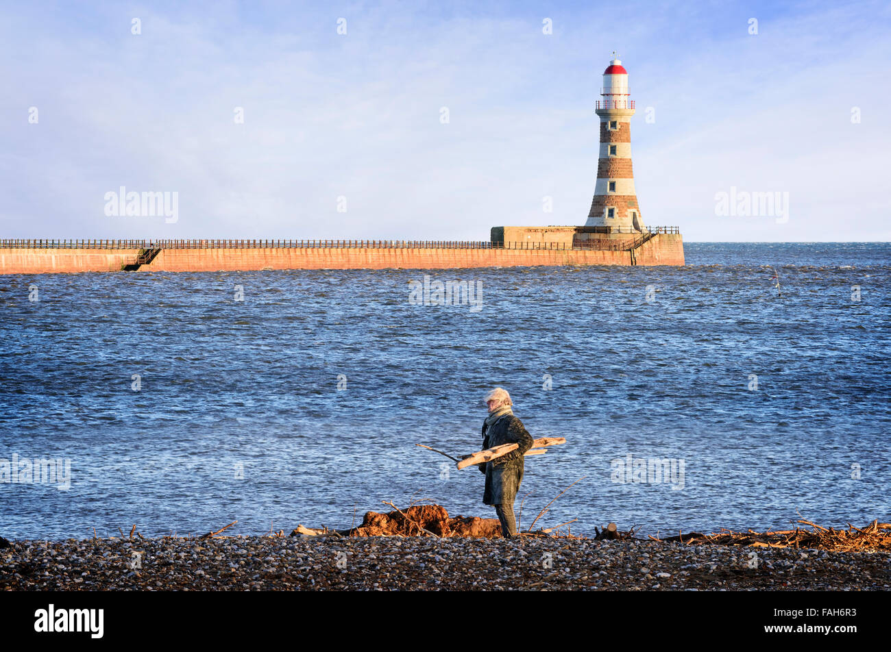 Uomo anziano raccogliendo driftwood su Roker Beach Foto Stock