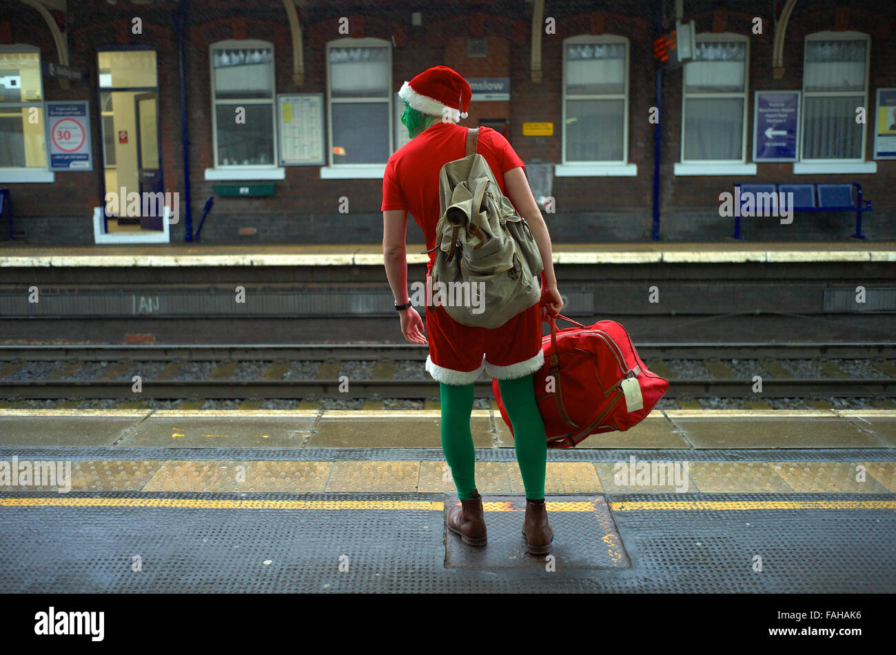 Festive traveler attende il suo treno sulla piattaforma. Foto Stock