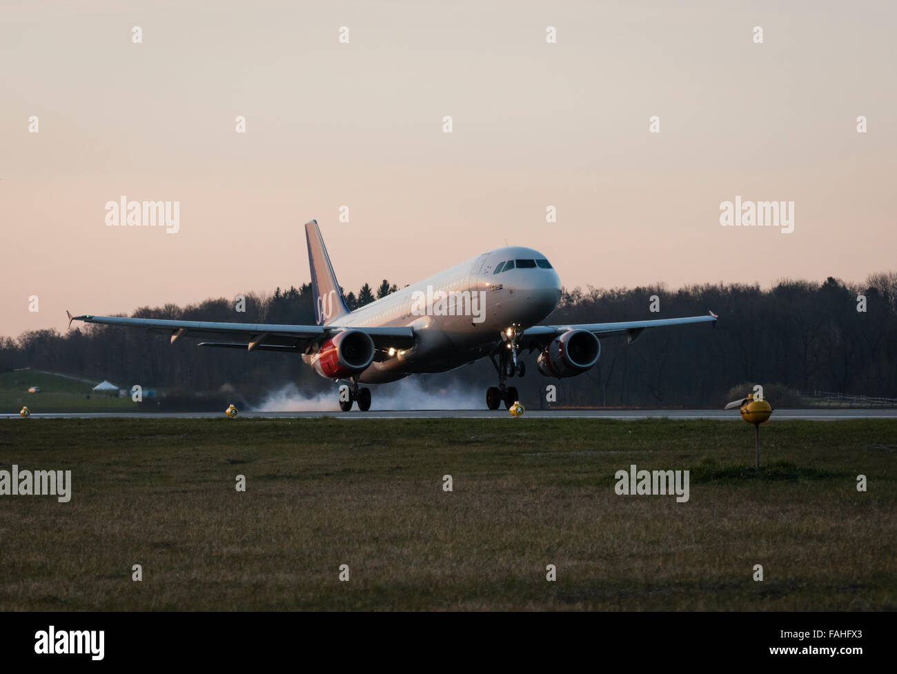 Fumo derivante dalla combustione di gomma è il sollevamento da pneumatici di un Airbus aerei passeggeri a destra dopo il touchdown all'aeroporto di Zurigo. Foto Stock