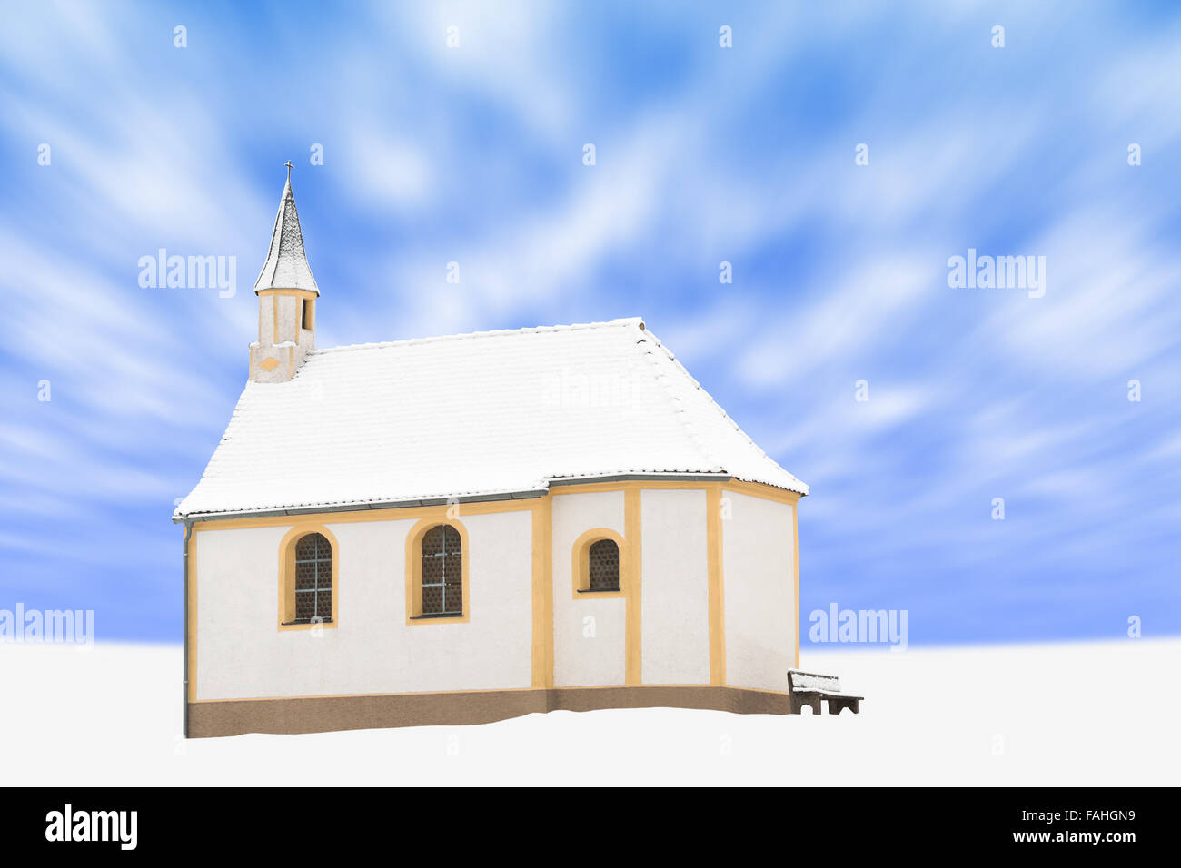 In piedi da solo staccato di un piccolo edificio di inverno coperto di neve e la cappella cattolica contro blu cielo molto nuvoloso Foto Stock