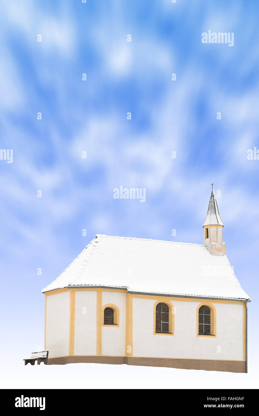 Piccola chiesa invernale o snowbound singola piccola cappella magazzino verticale foto con blured in movimento le nuvole nel cielo blu Foto Stock