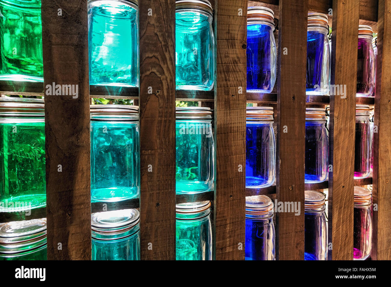 Colorato vasetti di vetro in Wall display nel telaio in legno Foto Stock