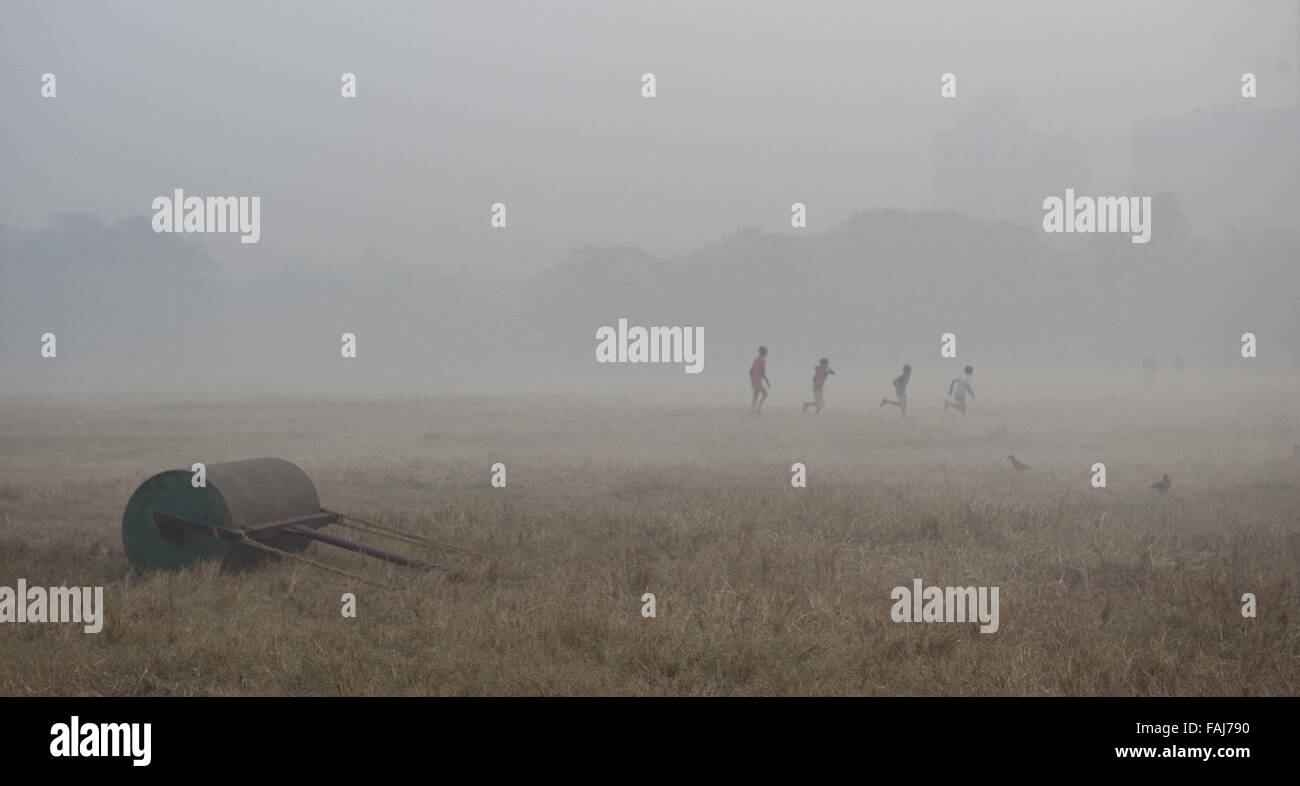 Kolkata, lo stato indiano del Bengala Occidentale. 30 Dic, 2015. Indian giocare i bambini nel mezzo della fitta nebbia in Kolkata, capitale dello stato indiano del Bengala Occidentale, 30 dic. 2015. Nebbia fitta frequenta India del nord in inverno, causando ritardi nel traffico e disturbi dell'aria e orari ferroviari. Credito: Tumpa Mondal/Xinhua/Alamy Live News Foto Stock