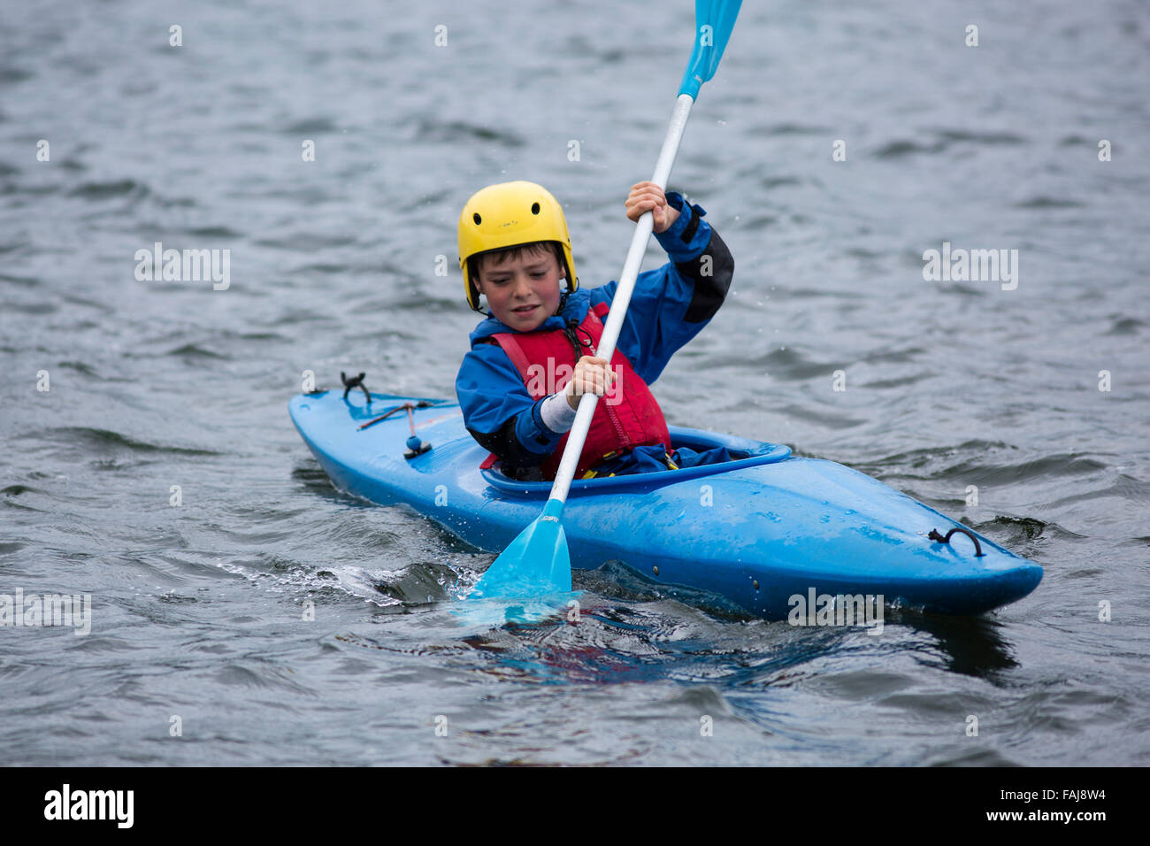 Ragazzo pagaie in kayak sul lago Foto Stock