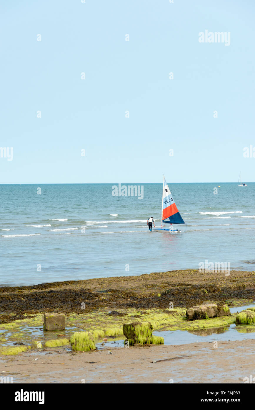 Un uomo lanciando un windsurf sul isola di Wight REGNO UNITO Foto Stock