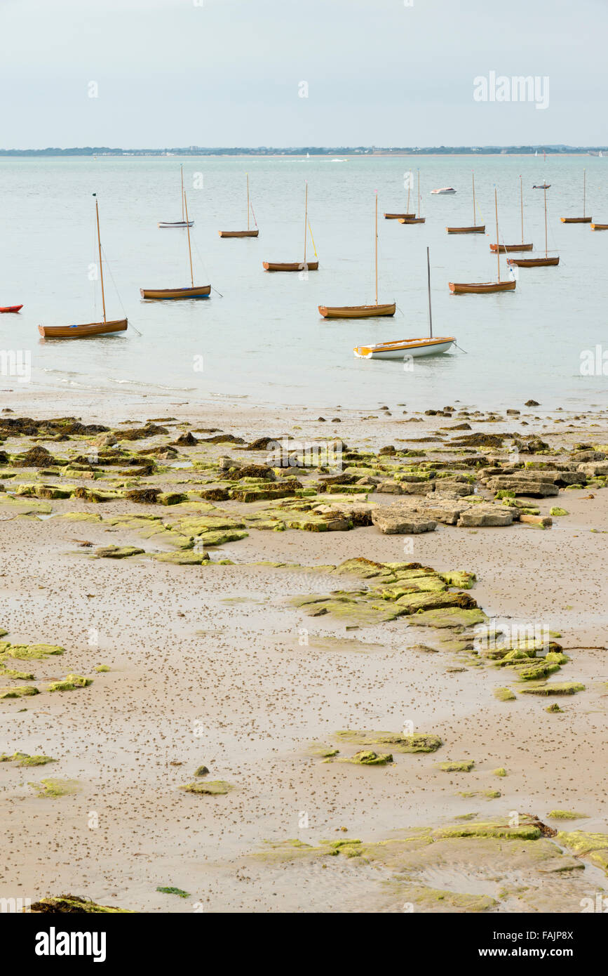 Piccole imbarcazioni a vela di legno barche a vela o dingies ormeggiata in se sull'Isola di Wight UK a bassa marea Foto Stock