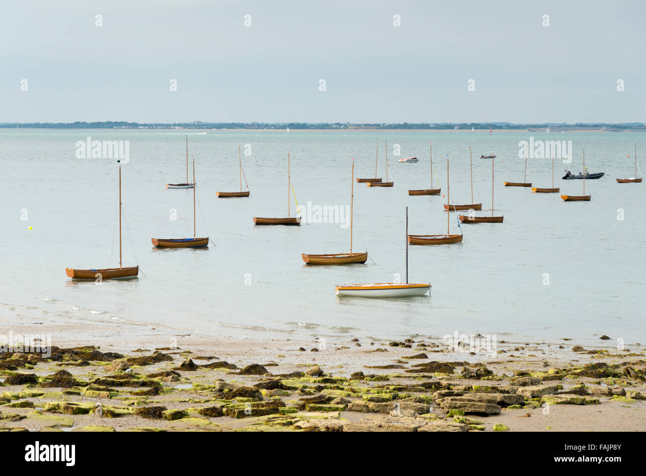 Piccole imbarcazioni a vela di legno barche a vela o dingies ormeggiata in se sull'Isola di Wight UK a bassa marea Foto Stock