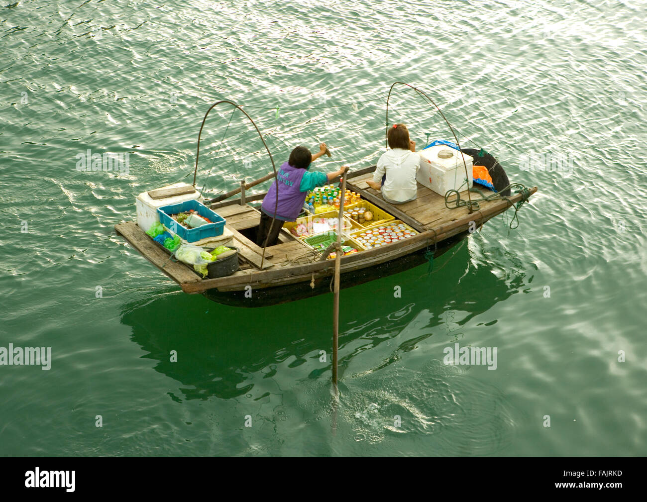Mercato galleggiante, vietnamita che vende frutta colorata da una barca a remi, ha Long Bay, Vietnam, Sud-est asiatico Foto Stock