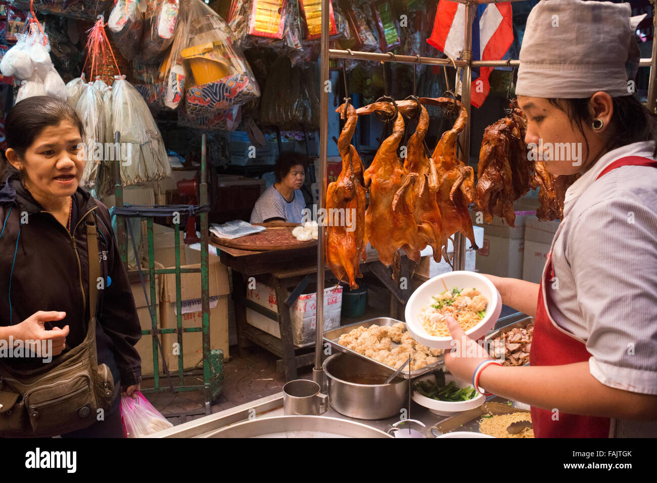 Cooker e torrefatto al tramonto in un restuarnt. Bangkok Chinatown mercato, Thailandia. Thanon Yaowarat road a notte nel centro di Chinatown d Foto Stock