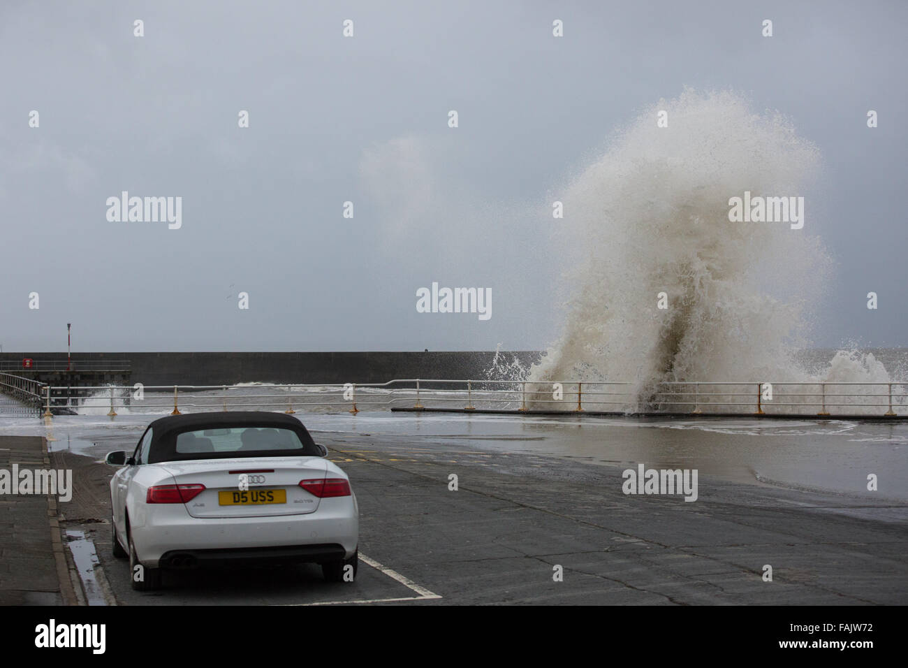 Aberystwyth, Wales, Regno Unito. Il 31 dicembre 2015. La Vigilia di Capodanno. . 'Wave addio al 2015". Come i resti di tempesta Frank coincidono con una alta marea, onde enormi ancora una volta la pastella di città del mare come i passanti a guardare. Credito: Alan Hale/Alamy Live News Foto Stock