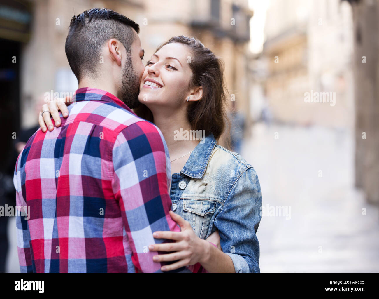 Caloroso benvenuto di felice bruna ragazza e il suo fidanzato al di fuori Foto Stock