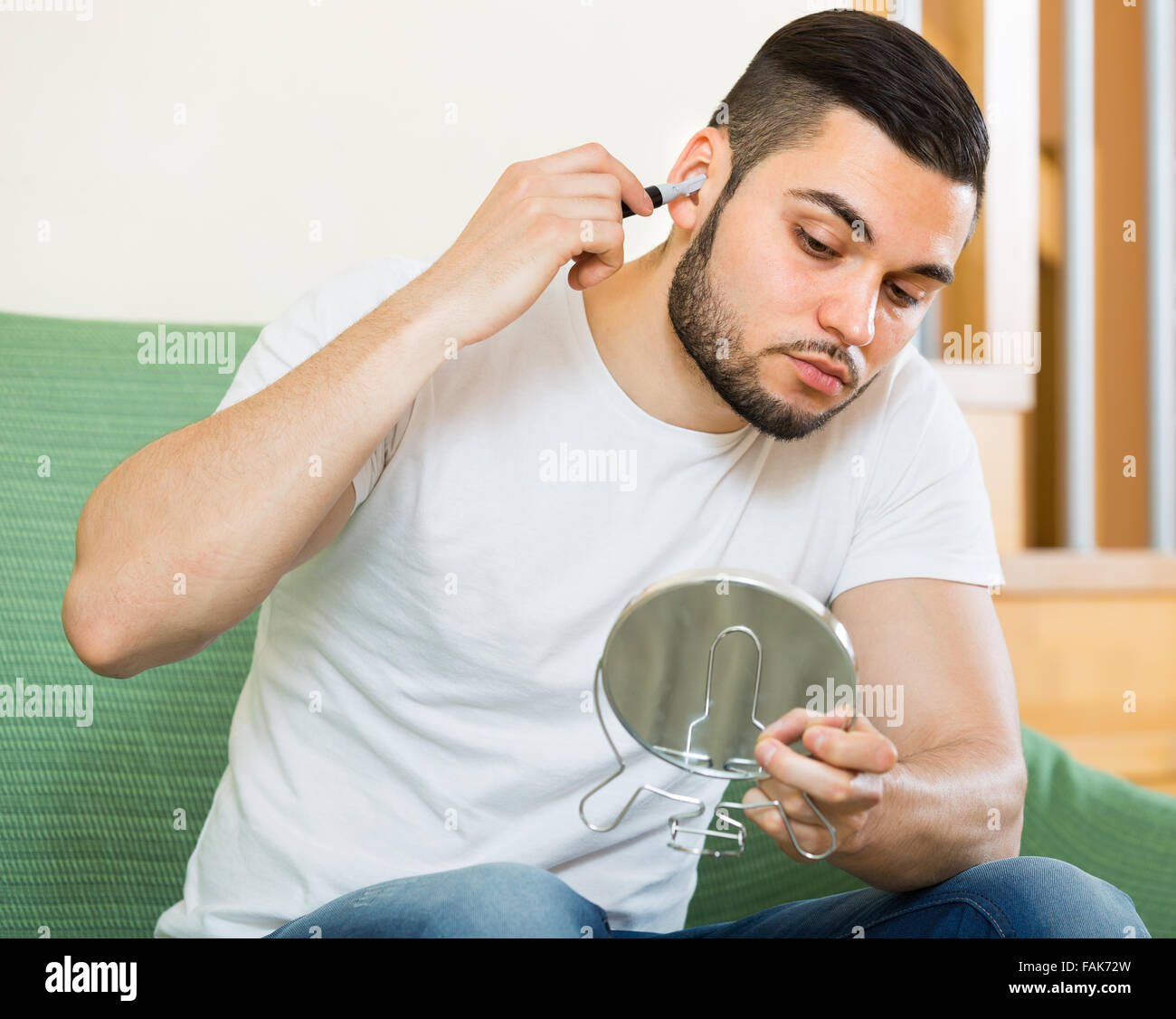 American guy rimuovere i peli dal naso e orecchie con trimmer Foto stock -  Alamy