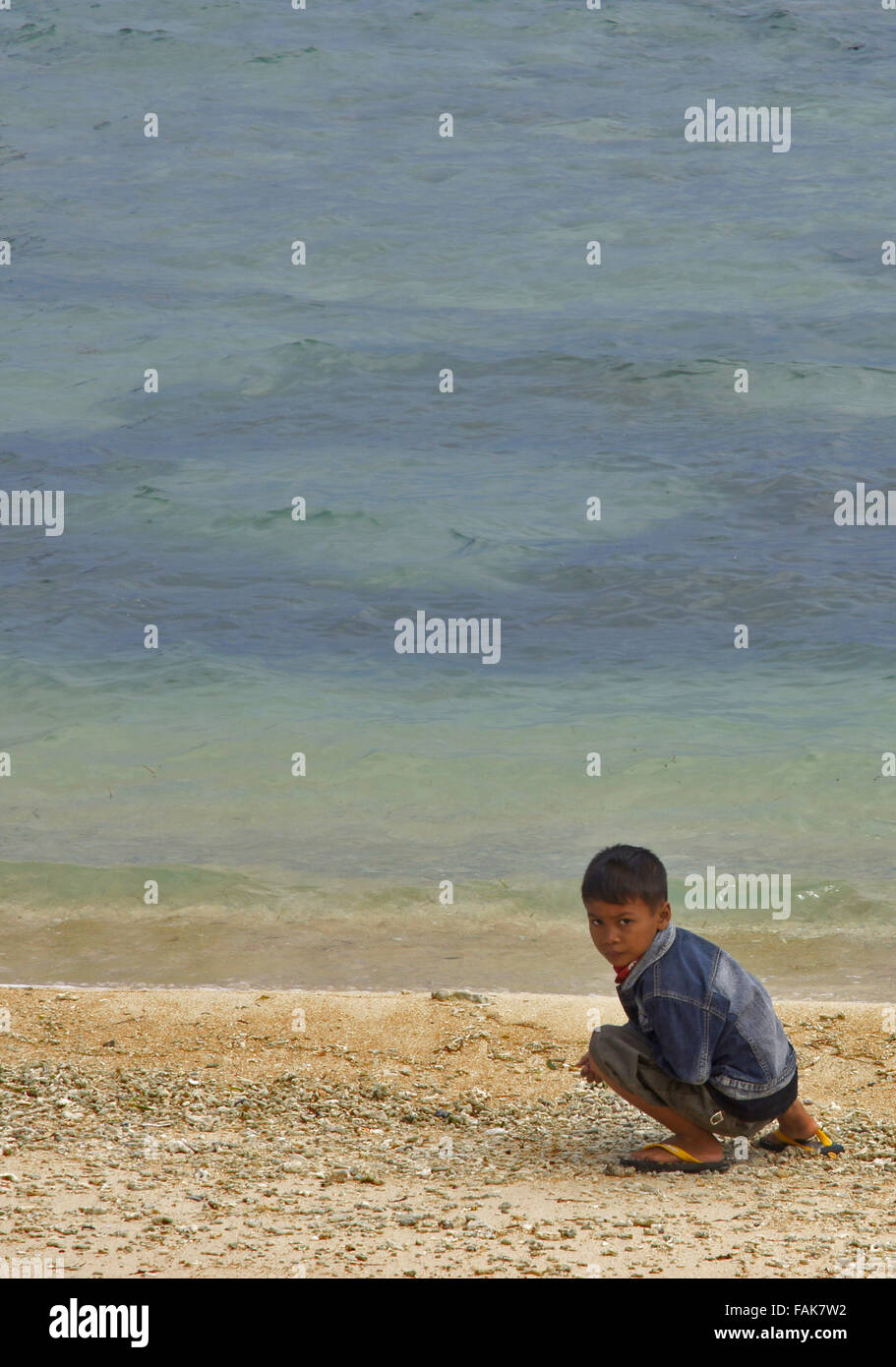 Ragazzo locale gioca sulla spiaggia sull Isola Gili, Indonesia Foto Stock