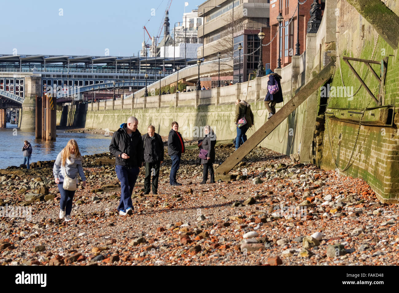 Le persone che si godono la giornata di sole sulla riva del fiume Tamigi, Londra England Regno Unito Regno Unito Foto Stock