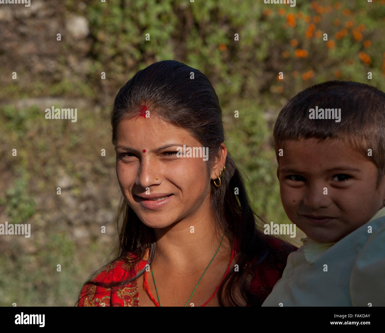 Giovane donna Nepalese che trasportano bambini in Himalaya. Foto Stock