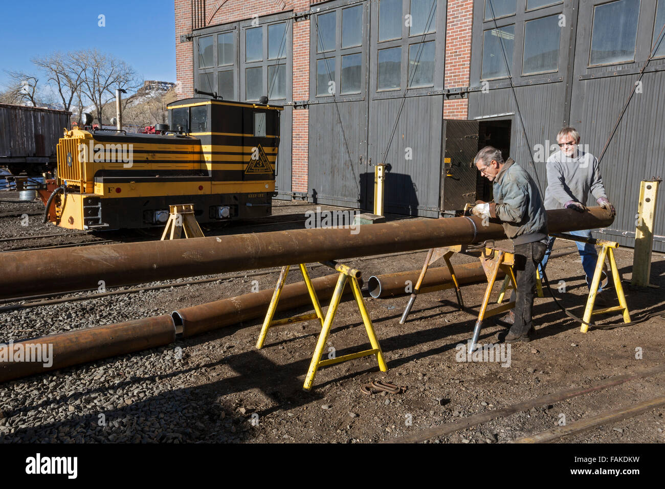 Golden, Colorado - Lavoratori tagliare il tubo al di fuori del roundhouse riparazione/restauro edificio presso la Colorado Railroad Museum. Foto Stock
