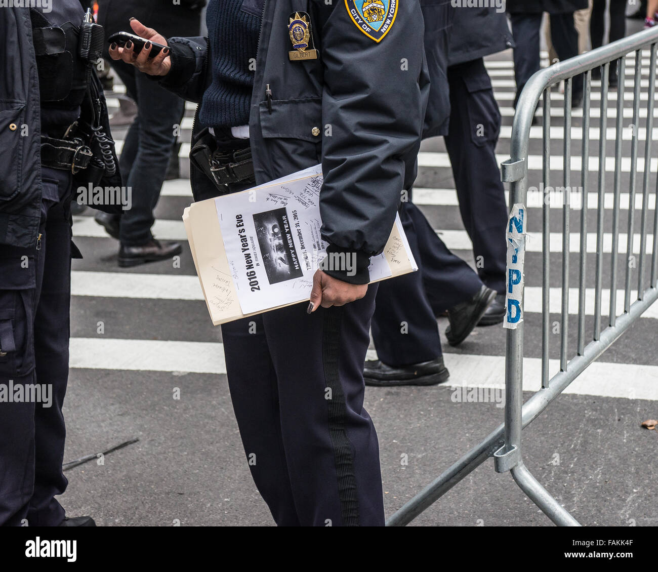 New York, Stati Uniti. 31 Dic, 2015. Un funzionario di NYPD contiene una cartella di note per la sera della attività di pattuglia. Con un maggiore grado di sicurezza a causa della minaccia di un attacco terroristico come quelle di Parigi e di San Bernardino, preparazioni per New York City annuali di Times Square Veglione di Capodanno riflettono la città la volontà di mantenere la pubblica sicurezza in tale massa incontri pubblici. Credito: Albin Lohr-Jones/Pacific Press/Alamy Live News Foto Stock