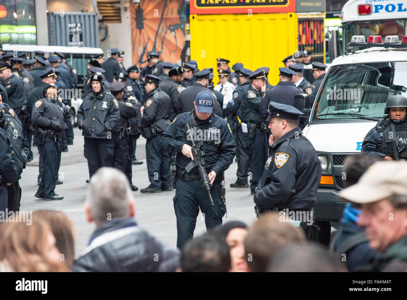 New York, Stati Uniti. 31 Dic, 2015. Un counterterrism NYPD officer (centro) controlla la sua mitragliatrice mentre la guardia nei pressi One Times Square. Con un maggiore grado di sicurezza a causa della minaccia di un attacco terroristico come quelle di Parigi e di San Bernardino, preparazioni per New York City annuali di Times Square Veglione di Capodanno riflettono la città la volontà di mantenere la pubblica sicurezza in tale massa incontri pubblici. Credito: Albin Lohr-Jones/Pacific Press/Alamy Live News Foto Stock