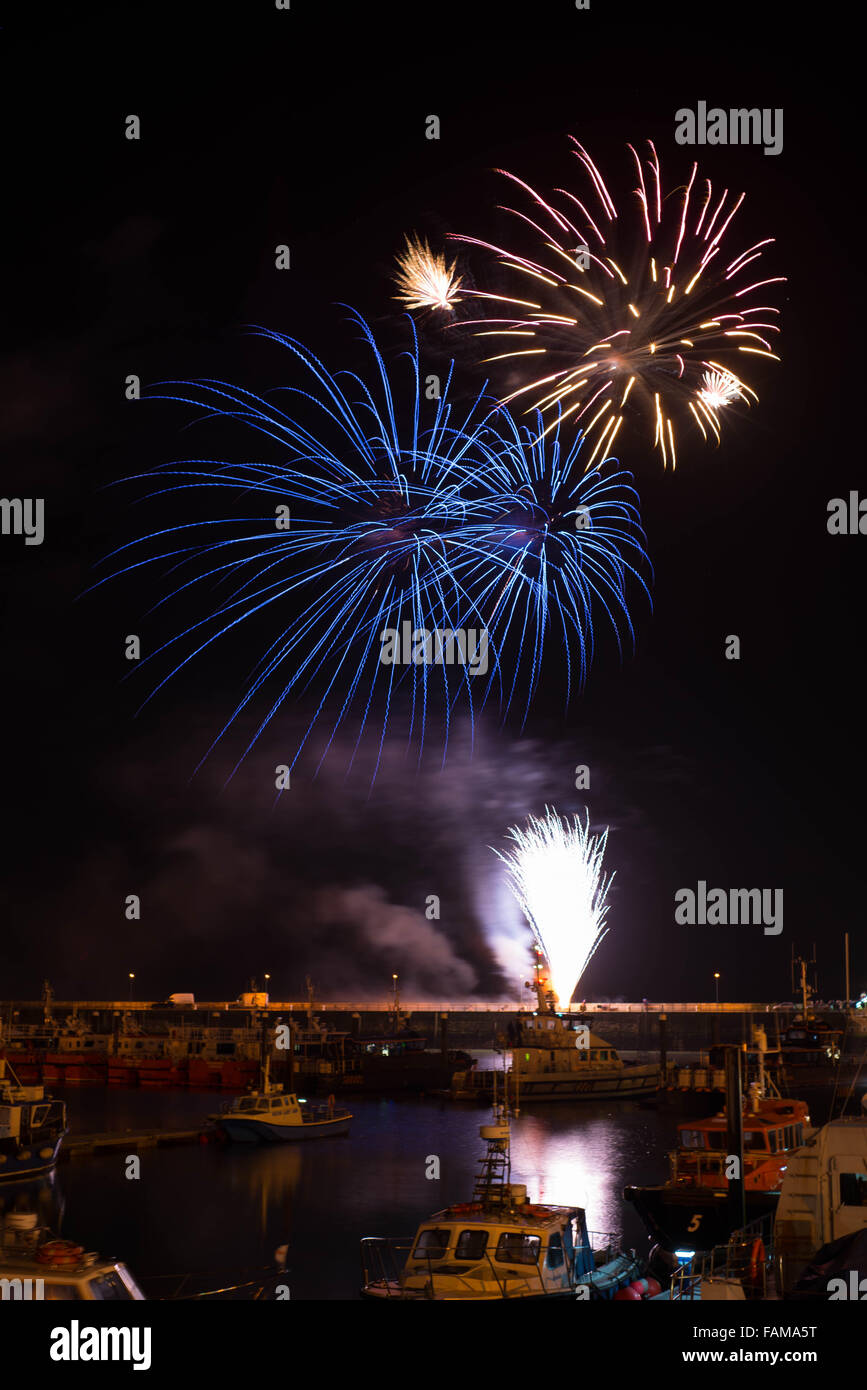 Capodanno fuochi d'artificio a Ramsgate Royal Harbour con la flotta commerciale in primo piano. Foto Stock