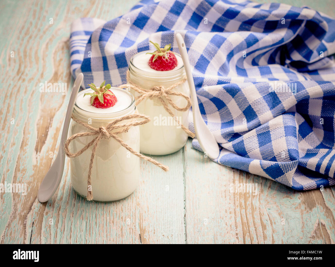 Yogurt Greco, di vetro con le fragole e il cucchiaio in ceramica Foto Stock