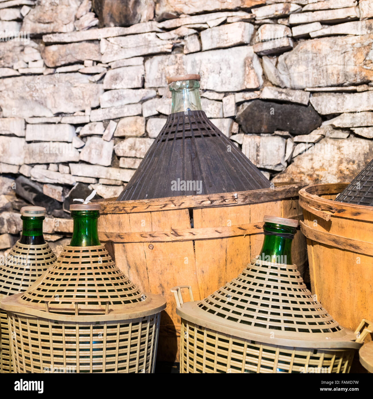 Damigiane di vino in una cantina in pietra. Foto Stock