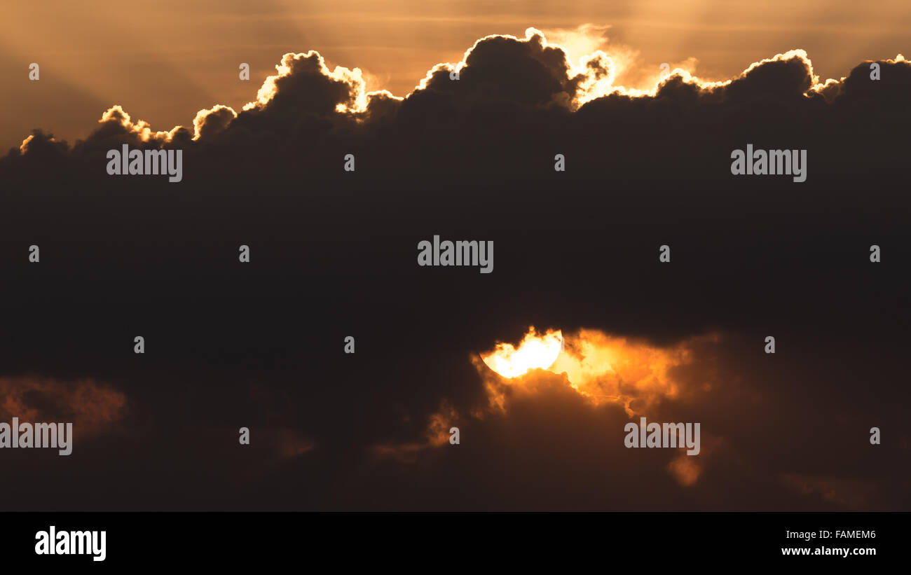 Sun andando verso il basso prima di notte era dietro il cloud Foto Stock