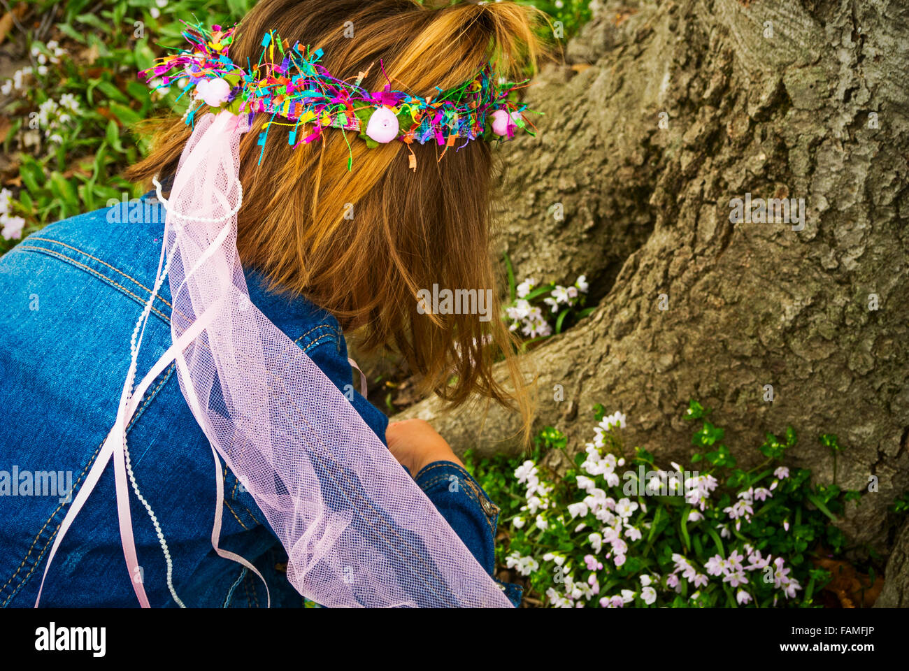 Ragazza a caccia di fiori alla base di un albero in Sheridan, IN, USA La fotografia da Jeffrey Wickett, fotografia NorthLight LLC, www Foto Stock