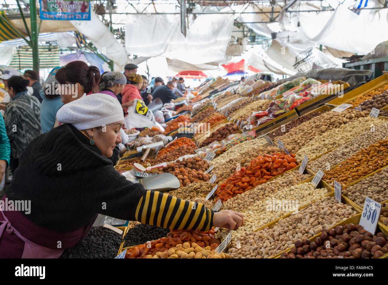 Bishkek, Kirghizistan - Ottobre 2, 2014: una signora la vendita di frutta secca al bazar di SSL. Foto Stock