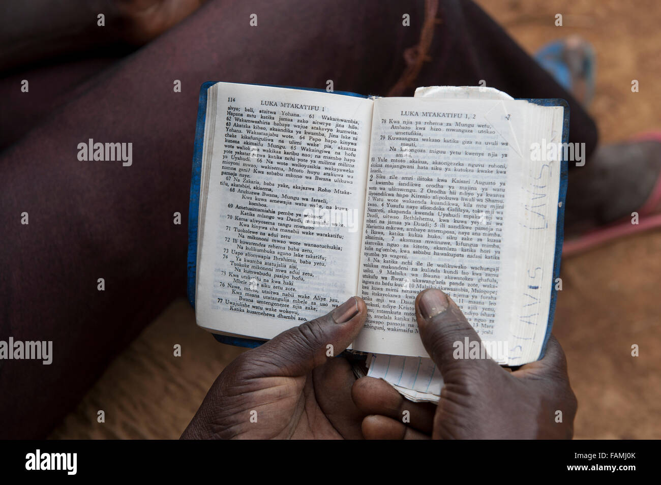 Donna keniota leggendo la Bibbia per la sua famiglia. Kenya. Foto Stock