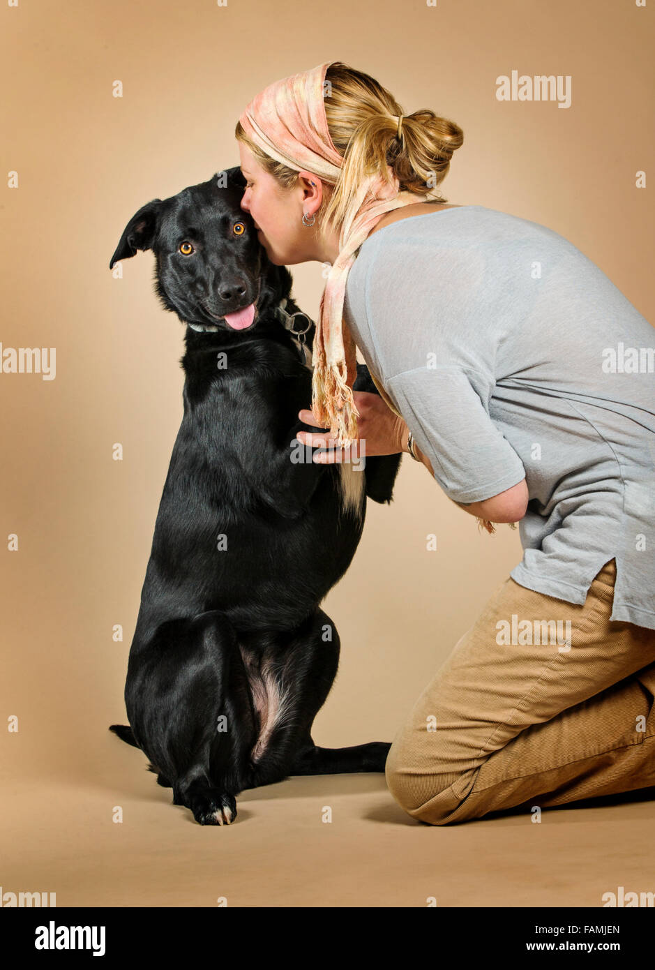 Ritratto in studio di attraente bionda donna caucasica con il suo nero laborador - mix collie razza cane Foto Stock